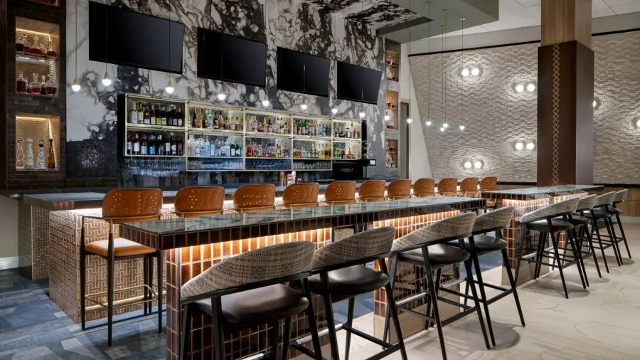 Hospitality bar framed by a black-and-white large-scale wallcovering mural.