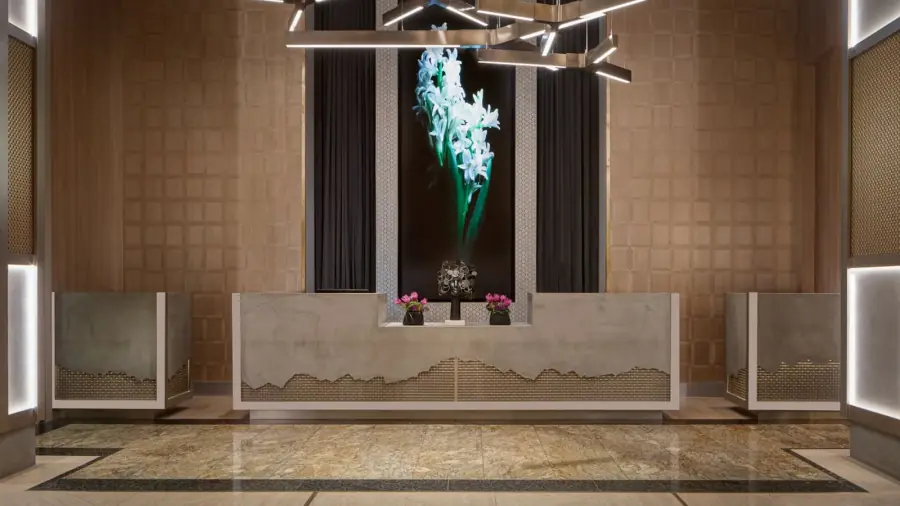 Hotel reception desk framed by patterned wall finishes and sculptural lighting.