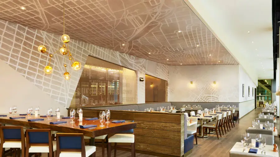 Large map mural wallcovering installed across commercial walls and an architectural ceiling feature.