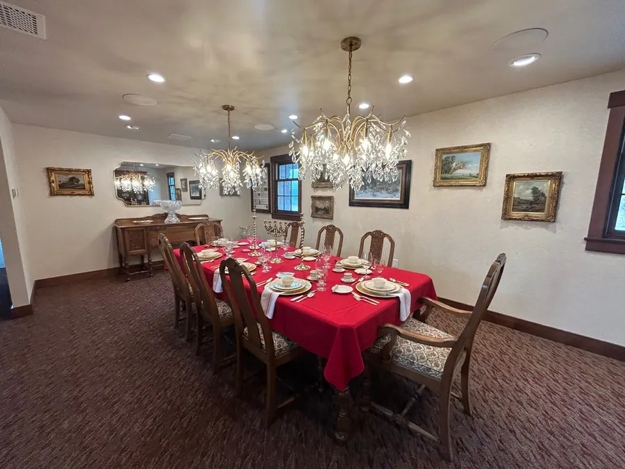 Light neutral textured wallcovering installed throughout a formal dining room with crystal chandeliers.