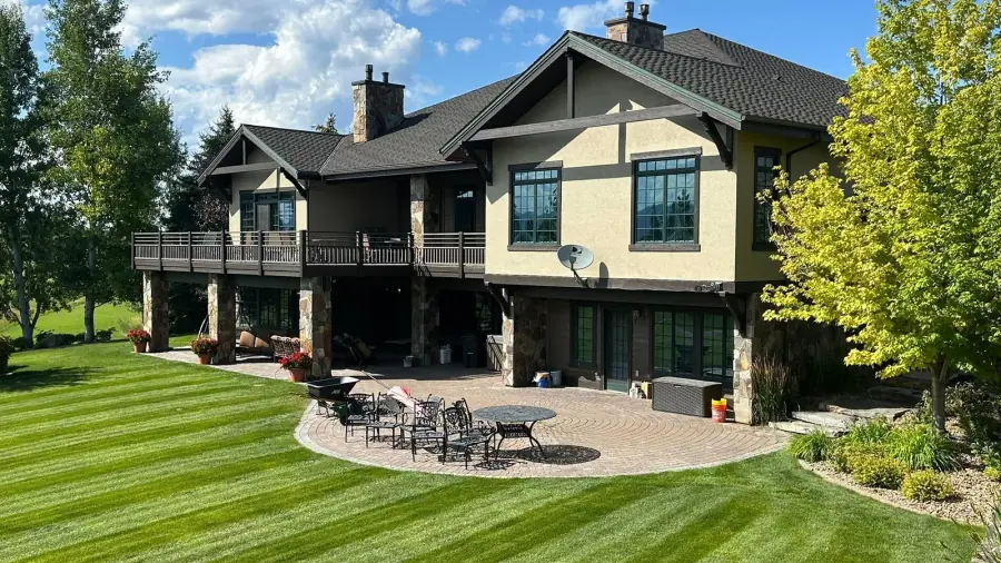 Large mountain home with a completed painted exterior surrounded by trees.