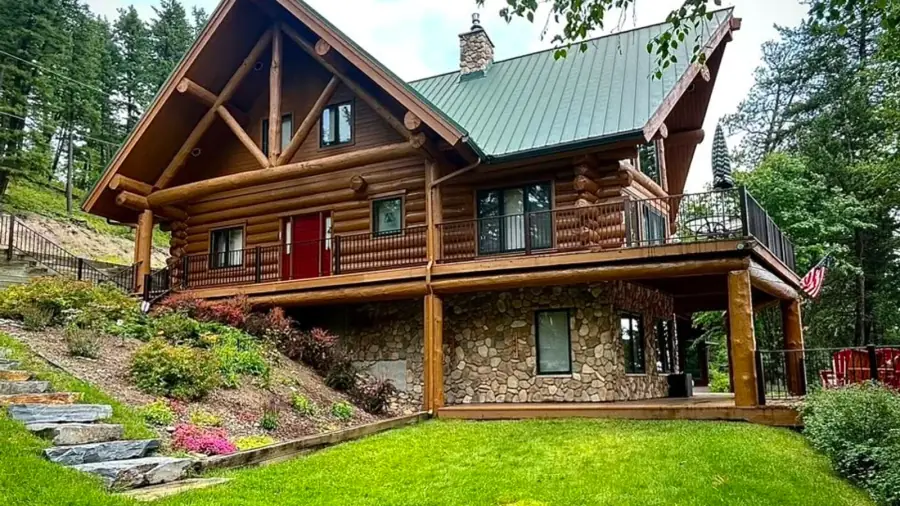 Log home with a completed stained exterior in a mountain setting.