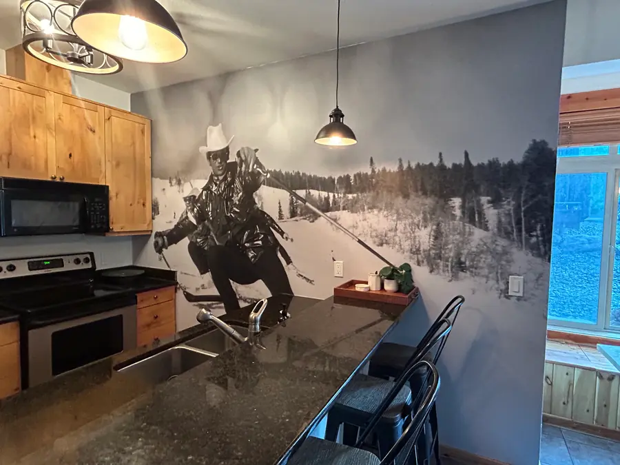 Black-and-white ski scene mural wallcovering installed across a kitchen wall.