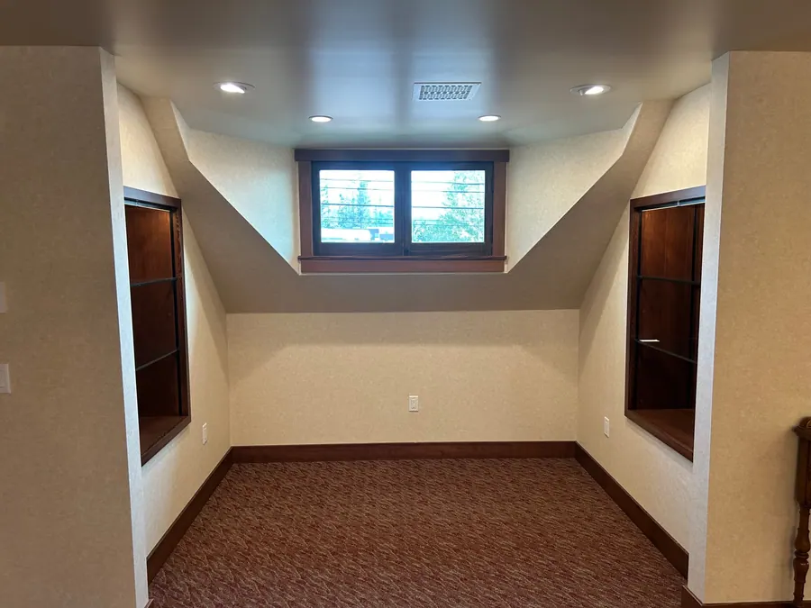 Neutral textured wallcovering precisely fitted around symmetrical niches and angled architectural details.